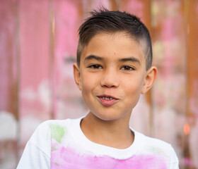 cheerful boy in hand painted t-shirt on painted fence background