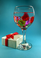 beautiful drink with hearts and a gift on a turquoise background. Festive background for Valentine's day. Romantic dinner