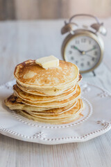 stack of pancakes, light morning, alarm clock in the background, light background