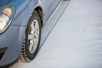 Close-up of car wheels rubber tires in deep winter snow. Transportation and safety concept.