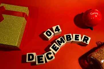 December 4 on wooden cubes .Gift box on a red background.The first month of winter.Calendar for December.New Year
