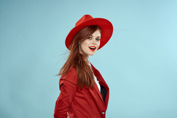 Beautiful woman in red hat jacket red lips long hair charm blue background