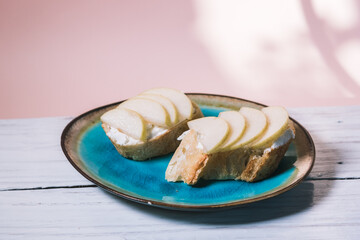Bruschetta made from baguette, cheese and pear are on a plate on the table. The concept of...