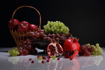 Still life on the theme of the harvest with pomegranate, grapes and apples