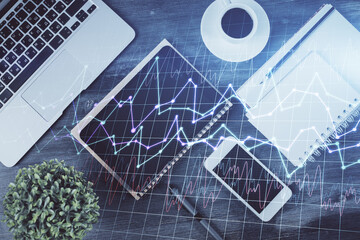 Double exposure of forex chart hologram over desktop with phone. Top view. Mobile trade platform concept.