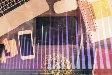 Double exposure of forex chart hologram over desktop with phone. Top view. Mobile trade platform concept.