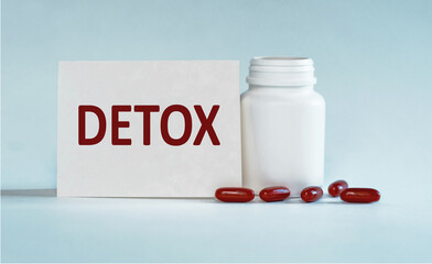 Detox written on a card near the bottle of pills, Medical concept