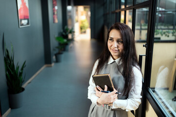 smart brunette woman of Caucasian appearance with glasses, a white shirt. a Manager in the banking sector works remotely remotely from home makes tasks plans strategy records for new projects