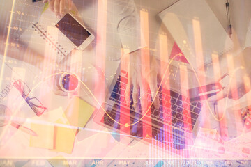 Multi exposure of man's hands typing over computer keyboard and forex graph hologram drawing. Top view. Financial markets concept.