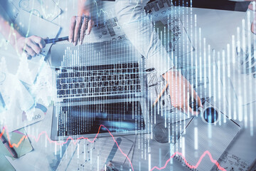 Double exposure of man and woman working together and financial graph hologram. Business concept. Computer background.