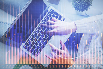 Double exposure of woman hands working on computer and forex chart hologram drawing. Top View....