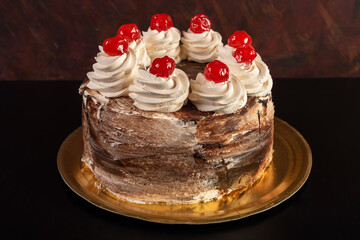 party cake for events, with cream, chocolate, cherry colored sprinkles, very delicate decorated kiwis