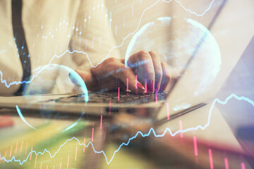 Double exposure of businesswoman hands typing on computer and financial graph hologram drawing. Stock market analysis concept.