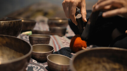 Asian guy playing Tibedt singing copper cups on a viewing mountain