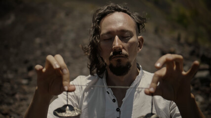 Asian guy playing Tibedt singing copper cups on a viewing mountain