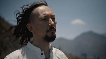 Asian guy playing Tibedt singing copper cups on a viewing mountain