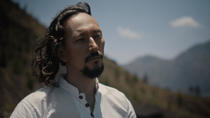 Asian guy playing Tibedt singing copper cups on a viewing mountain