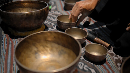 Asian guy playing Tibedt singing copper cups on a viewing mountain