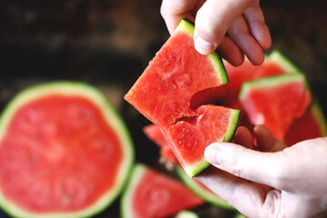 Selective focus. Watermelon slices in hands. Watermelon pulp. Sliced watermelon into pieces.