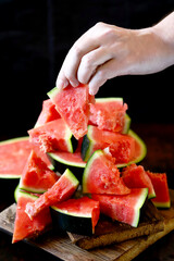 Selective focus. Watermelon slices in hands. Watermelon pulp. Sliced watermelon into pieces.
