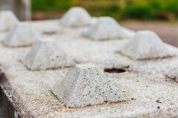 Close up of concrete block barriers showing the top locating pins.