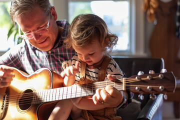 Grandpa and granddaughter playing guitar