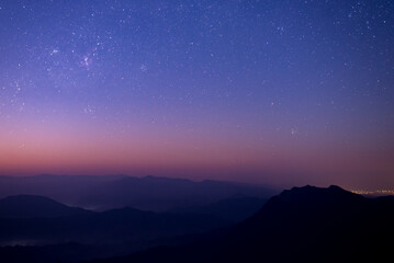 Fototapeta na wymiar Night landscape with colorful star and milky way and beautiful twilight sky before sunrise over the mountain.