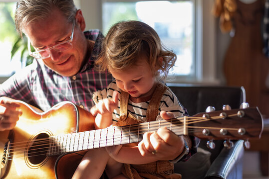 Grandpa And Granddaughter Playing Guitar