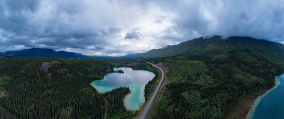 Panoramic View of Lakes from Above surrounded by Forest, alongside Scenic Road at Twilight. Aerial Drone Shot taken in Canadian Nature. Klondike Highway, South of Whithorse, Yukon, Canada.