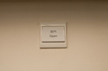 White plastic light electric switch in English and Chinese on white plain wall