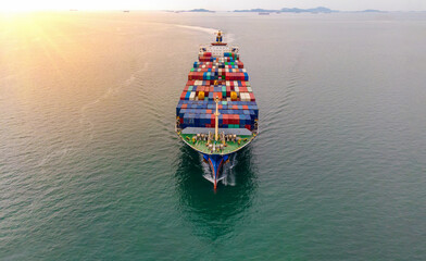 Aerial in front of cargo ship carrying container and running with Crew that working rope stand by...