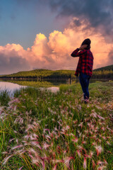 Girl Standing with Beautiful Scenery and wild flowers by the lake during a clear sunny evening in Canadian Nature. Taken near Whitehorse, Yukon, Canada.