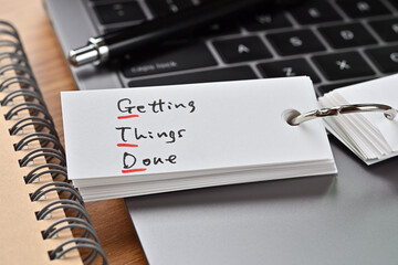 The words "GTD" written in a word book. Close-up. It is an acronym for "Getting Things Done".