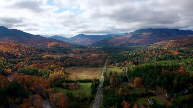 Aerial flythrough of Road Through Autumn Trees with Fall Colors in New England