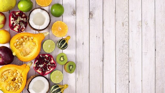 Fresh sliced fruits appear on left side of light wooden theme. Stop motion 