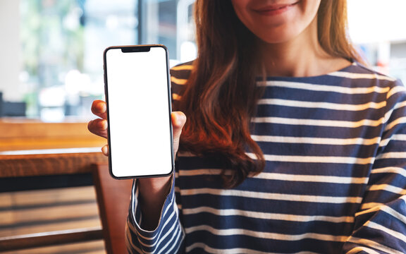 Mockup image of a beautiful asian woman holding and showing a mobile phone with blank white screen