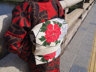 Close up of an Asian woman's obi in a traditional Japanese kimono standing by the bridge, Kamo River, Kyoto, Japan