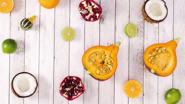Sliced citrus and tropic fruits blinking on light wooden theme. Stop motion 