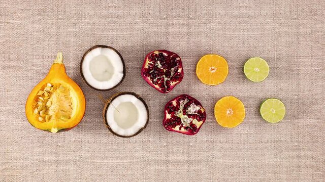 Pumpkin and two slices of coconut, pomegranate, orange and lime appear . Stop motion