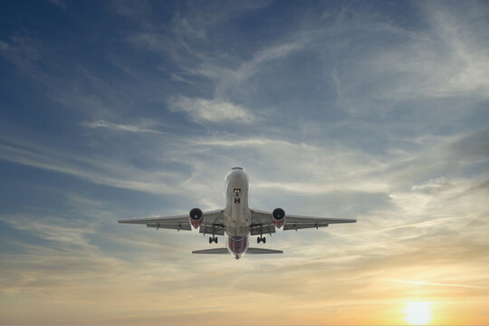 Airplane approaching with beautiful sunset in dramatic sky © Felix Mizioznikov