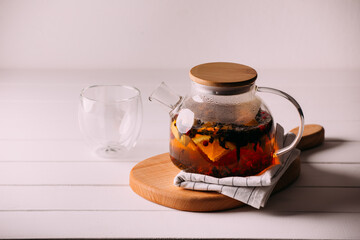 tea with fruit and berries in a glass teapot. tea for colds.