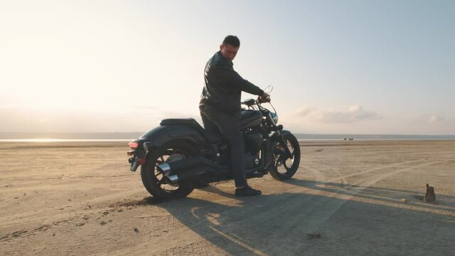 Motorcyclist Doing Tire Burnout In The Desert, Slow Motion. Professional Motorcyclist Drift On Sport Bike On A Dry Salt Lake And Ride Away