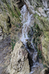 Fototapeta na wymiar small waterfall from the wall and cliff