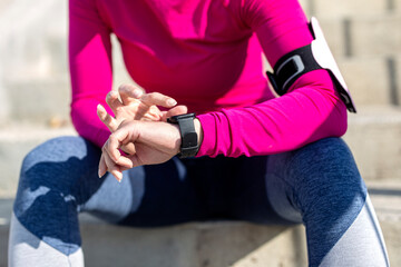 Fit woman looking at the watch after jogging