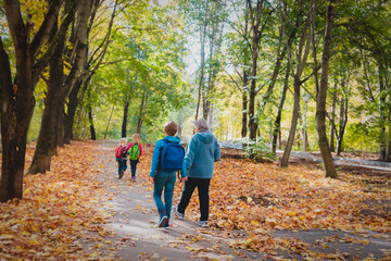 grandmother with kids walk in autumn nature