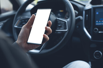Mockup of man driver using blank screen mobile phone inside a car