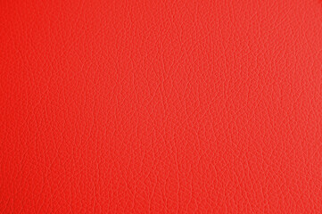 The texture of genuine leather has a red hue. Background background is a textured effect for the design. Artificial eco leather a piece of artificial leather