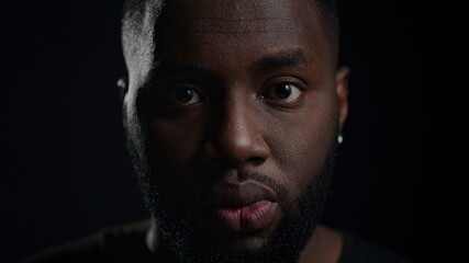 Joyful man posing in studio. Happy afro guy saying wow on black background