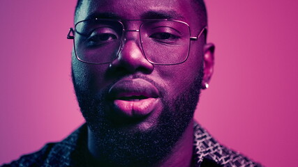 African american guy sending kisses in studio. Afro guy staring at lense indoors