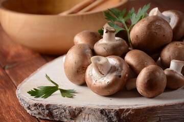 Fresh brown champignon mushrooms on wooden board